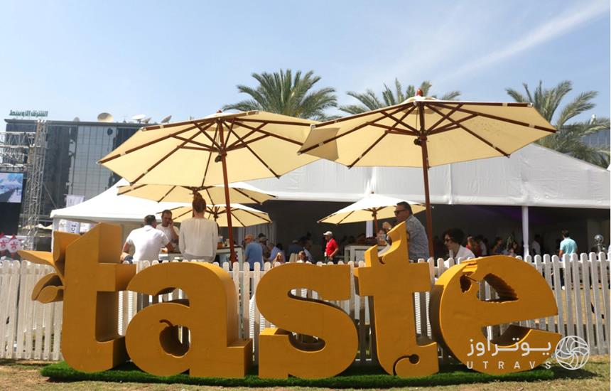 جشنواره «taste» دبی؛ لوگوی سفیدرنگ فستیوال روی نرده‌های سفیدی نصب شده‌است که آلاچیق‌های غذاخوری را از سایر نقاط شهر جدا کرده‌است.